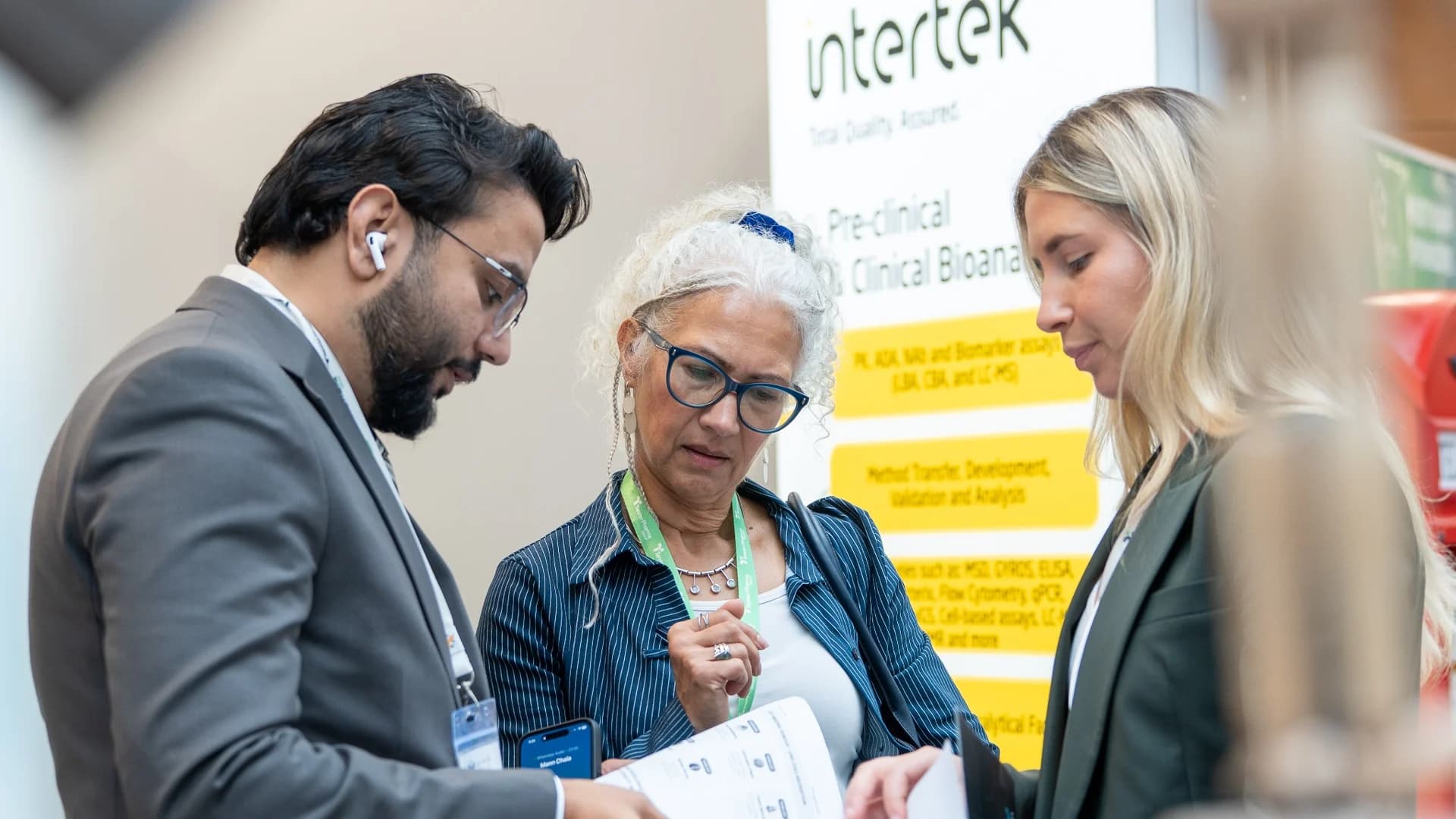 Delegates sharing notes in front of an exhibitor stand