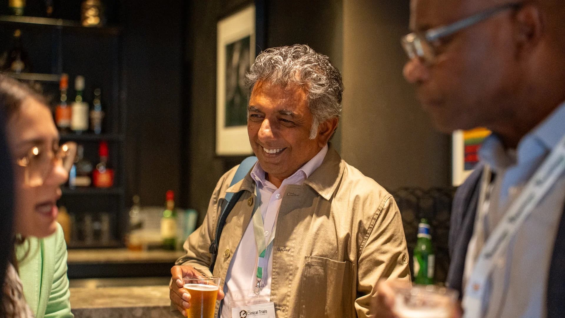 A delegate smiling during an informal drinks reception